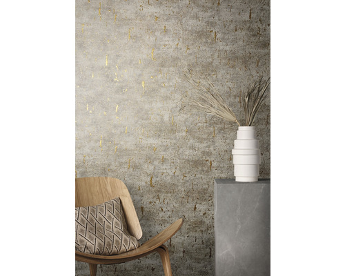 Miljöbild med stol, kudde, vas och en mönstrad tapet