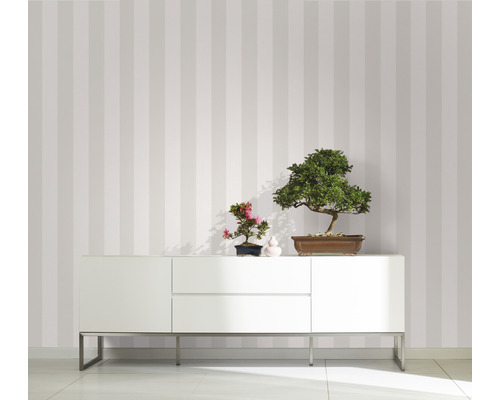 Inredningsdesign med randig tapet, skänk och bonsaiväxter