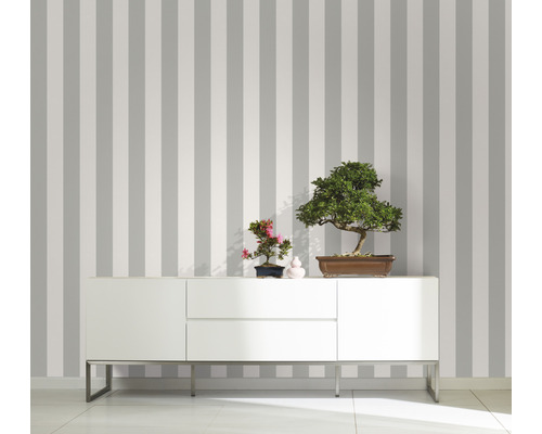 Rumsöversikt med randig tapet, skänk och bonsaiträd