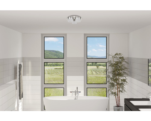 Badrum med fristående badkar, handdukstork, fönster och taklampa