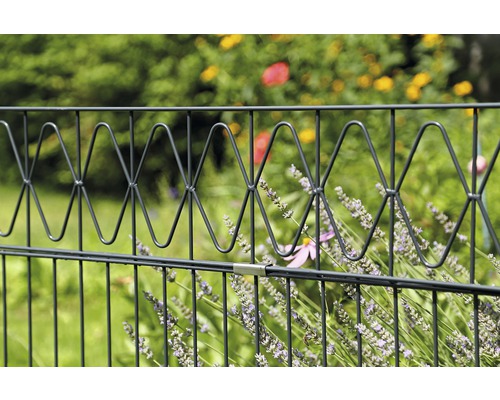 Metallstängsel med dekorativa element i trädgården