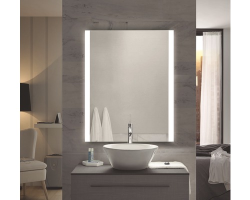 Modernt badrum med belyst spegel, tvättställsskål och tvättställsskåp