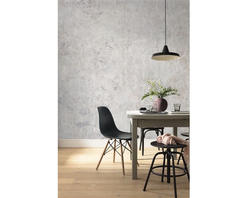 Matsal med matbord, stolar och grå väggtapet i betonglook