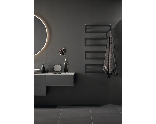 Modernt badrum med tvättställ, spegel med belysning och handdukstork