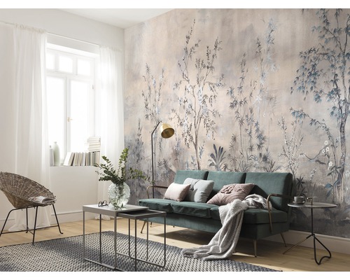Vardagsrum med blommig mönstertapet, soffa och fåtölj