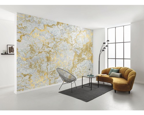 Vardagsrum med grå tapet med guldmönster, stol, soffa och bord