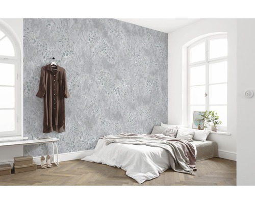 Ljust sovrum med mönstrad tapet, säng och trägolv