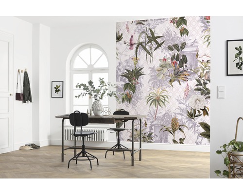 Ett ljust rum med ett bord, stolar och en vägg med botanisk tapet.