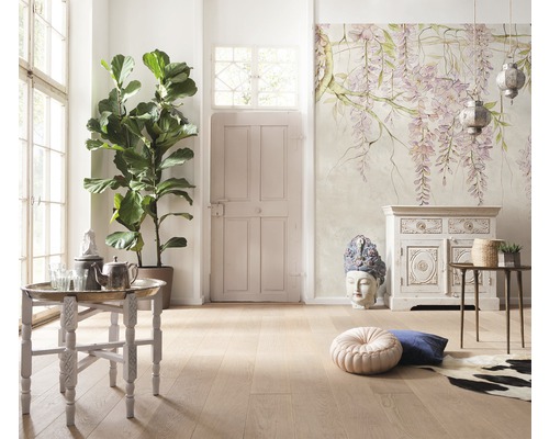 Ljust rum med fikonträd, bord, dekoration och en vägg med blommönster