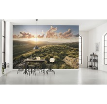 Ljust rum med fototapet av ett kuperat landskap i soluppgången och en matgrupp