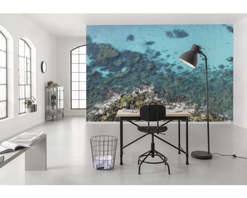 Ljust rum med skrivbord, stol, golvlampa och fototapet med havsmotiv