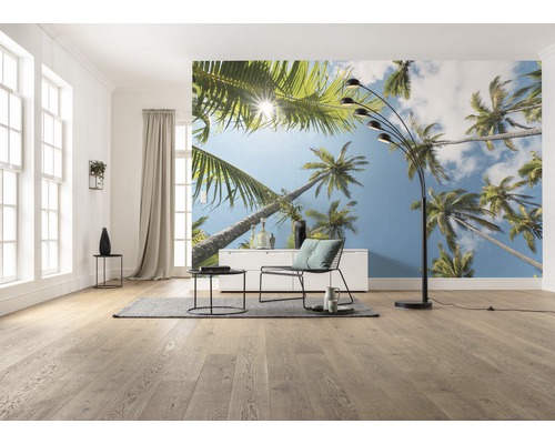Vardagsrum med fototapet med palmmotiv, golvlampa, fåtölj och bord