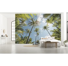 Ljust rum med fototapet med palmmotiv, säng och dekoration