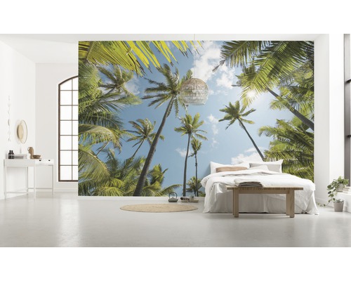 Ljust rum med fototapet med palmmotiv, säng och dekoration