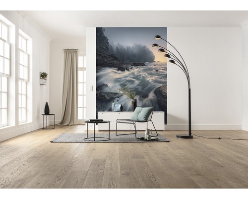 Ljust vardagsrum med trägolv, fototapet med flodmotiv och svart golvlampa.