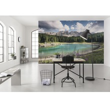 Ljust rum med en fotovägg som visar en sjö och berg, skrivbord och stol