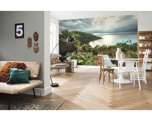 Vardagsrum med fototapet av en tropisk ö, en soffa, ett bord och stolar.