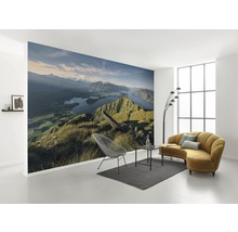 Vardagsrum med fototapet bergslandskap, soffa, fåtölj och matta