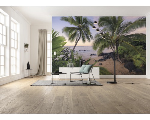 Ljust rum med fototapet av en palmstrand, inrett med stol, bord, golvlampa och matta