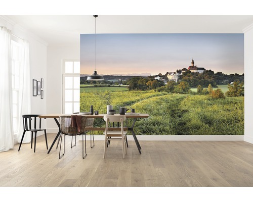 Ljust matrum med fotovägg som föreställer ett grönt landskap och en byggnad.