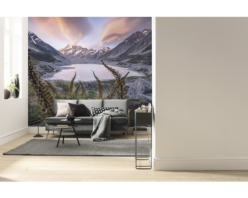 Vardagsrum med fototapet av ett bergslandskap med sjö och soffa.