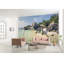 Vardagsrum med fotovägg av en tropisk strand, soffa, fåtölj och soffbord