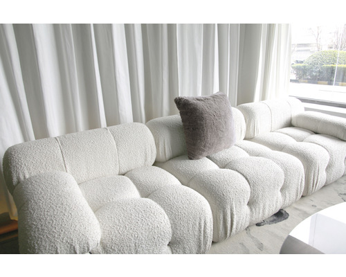 Ljust vardagsrum med stor modulsoffa och kudde