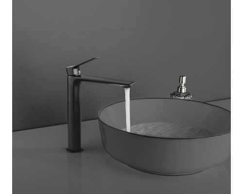 Tvättställsblandare bredvid handfat med vatten