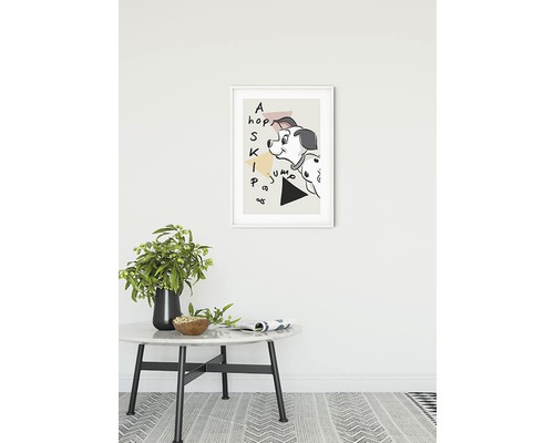 Dekorativ poster med dalmatinermotiv i ram över ett bord med vas och tidskrift
