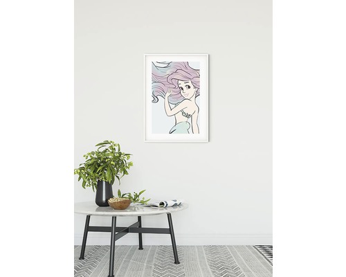 Inramad bild av Ariel sjöjungfrun på en vägg ovanför ett runt bord