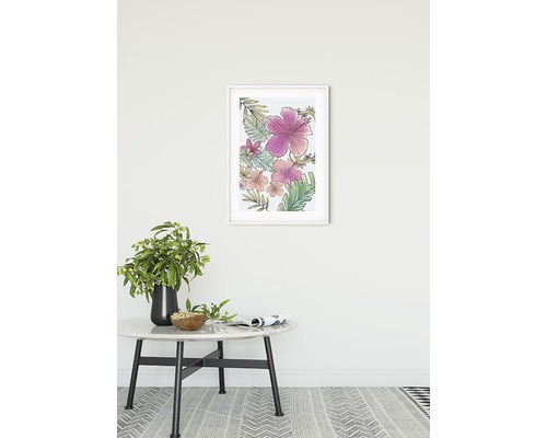 Inramad väggkonst med blommotiv ovanför ett bord