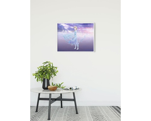 En inramad bild med Elsa från Frost hänger på väggen ovanför ett bord.