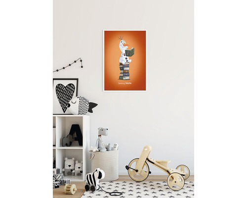 Dekorativ bild med en snögubbe som sitter på en stapel böcker och läser en bok