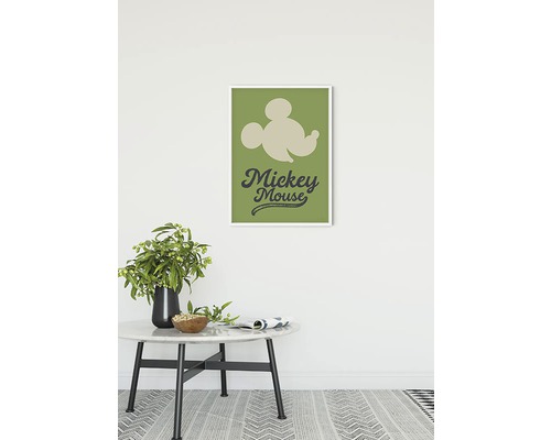 Dekorativ Mickey Mouse väggbild i ram ovanför ett bord