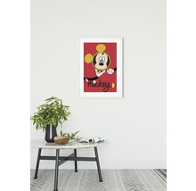 Inramad Mickey Mouse-bild på väggen ovanför ett bord