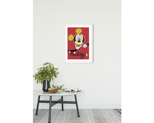 Inramad Mickey Mouse-bild på väggen ovanför ett bord