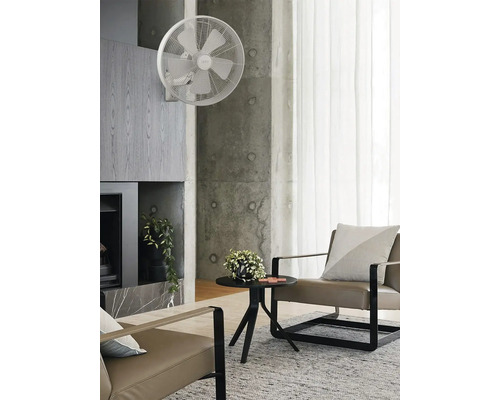 Vardagsrum med väggfläkt, fåtöljer och sidobord