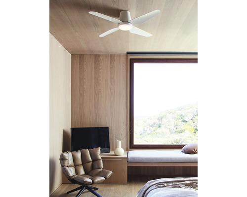 Sovrum med takfläkt, fåtölj, bänk och fönster.