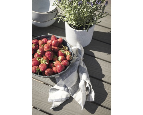 Jordgubbar i en skål bredvid en lavendelkruka på ett bord