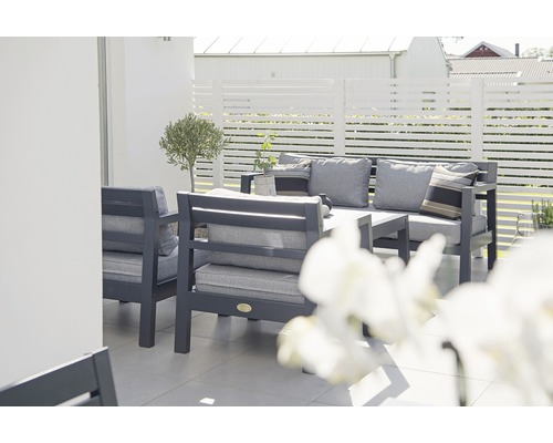 Trädgårdsloungegrupp med bord och dynor på en terrass