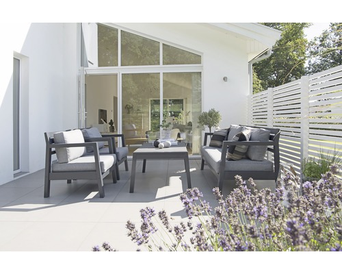 Uteplats med sittgrupp och växtdekoration framför ett hus