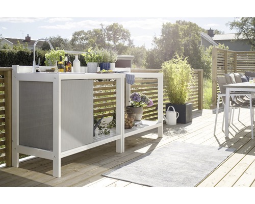 Ljus trädgårdsscen med utekök i trä, diskho, växter och dekoration på en träterrass