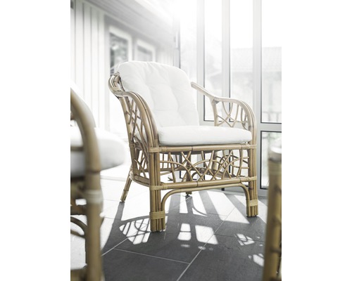 Korgstol med dyna i ljust rum