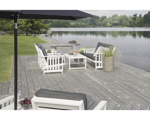 Trädgårdsmöbelset i trä på en terrass vid en sjö