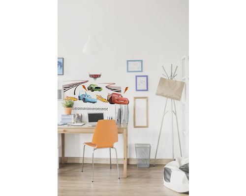 Dekorerat barnrum med väggdekaler med bilar ovanför ett skrivbord