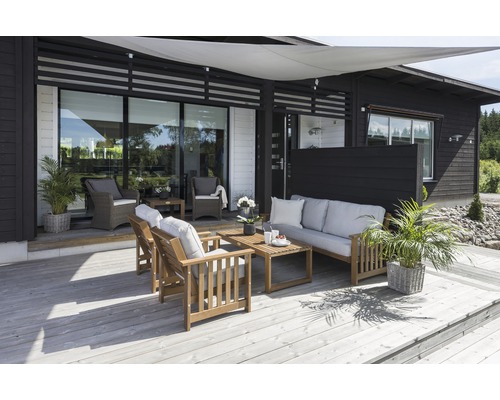 Terrass med trämöbler, solsegel och plantering framför ett modernt hus
