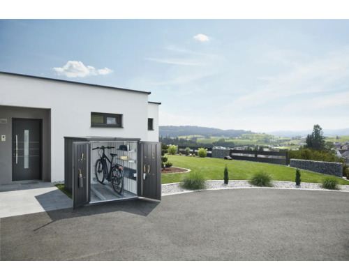 Cykelbox av metall med öppna dörrar bredvid ett modernt hus