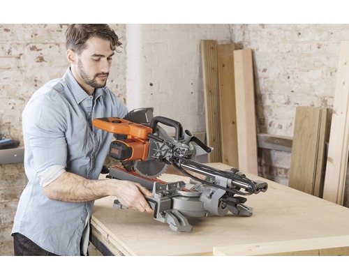 Man använder en kap- och geringssåg från Black and Decker på ett bord.