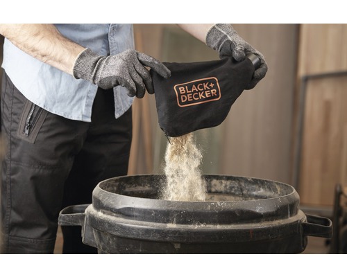 En person tömmer uppsamlingssäcken från en Black plus Decker lövblås i en behållare.