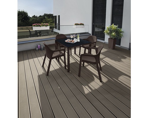 Trädgårdsscen med fyrkantigt bord och fyra stolar på en terrass